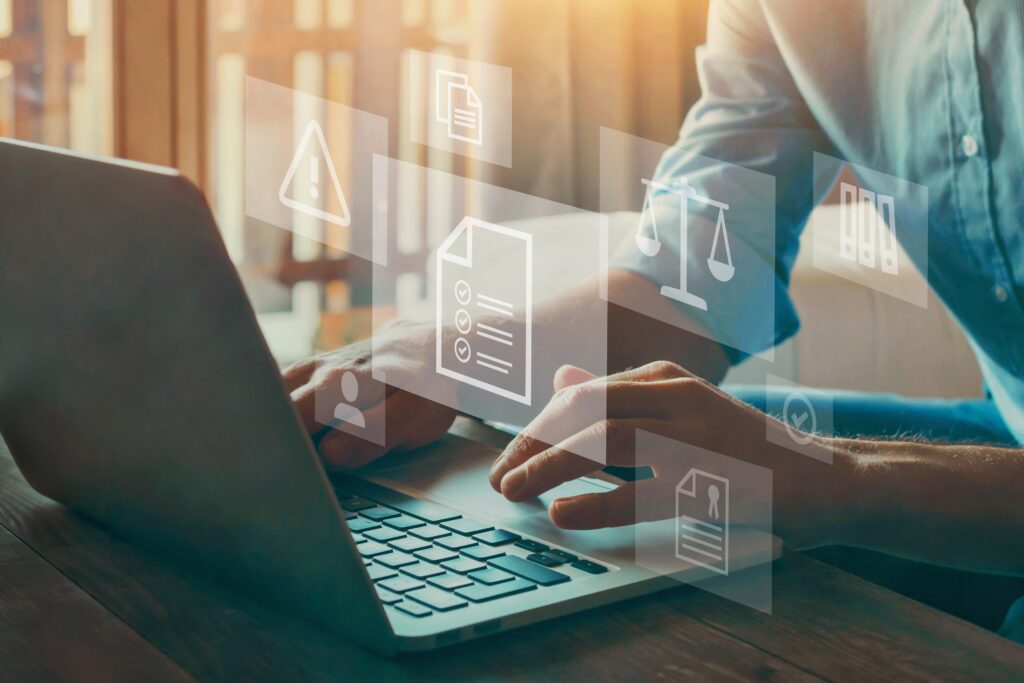 Person on a laptop setting up a learning management system (LMS) with graphic icons superimposed over top.